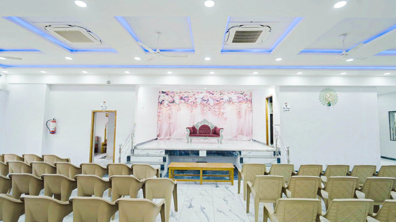 Main hall and stage at Aadhi's Mahal with floral backdrop and seating